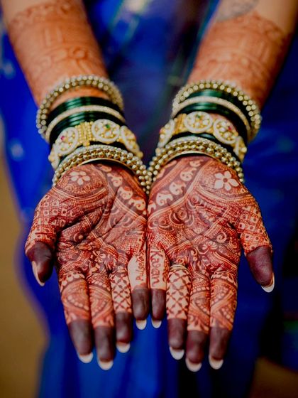 A stunning macro shot of the bride's hands, showcasing the deep, beautiful stain of her bridal mehendi.