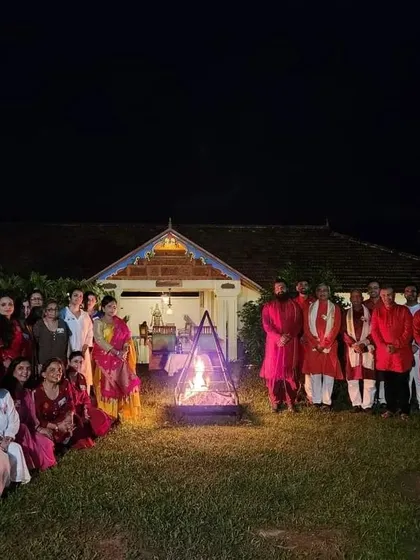 A group photo around a bonfire, a moment of warmth and community in Kerala.