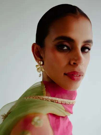 A close-up beauty shot for Esha Arora's collection. The focus is on the model's expression, the delicate earring, and the rich colors of the dupatta.