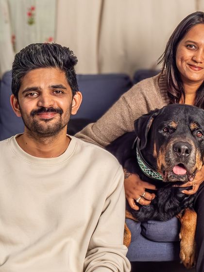 The whole family relaxing on the couch with their beloved Rottweiler, Jag. A perfect example of a cozy, candid, at-home family portrait.