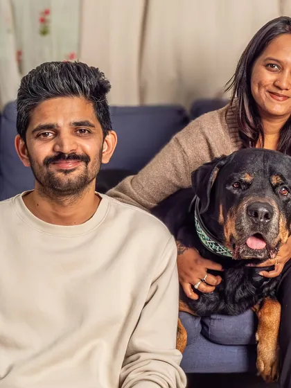 The whole family relaxing on the couch with their beloved Rottweiler, Jag. A perfect example of a cozy, candid, at-home family portrait.