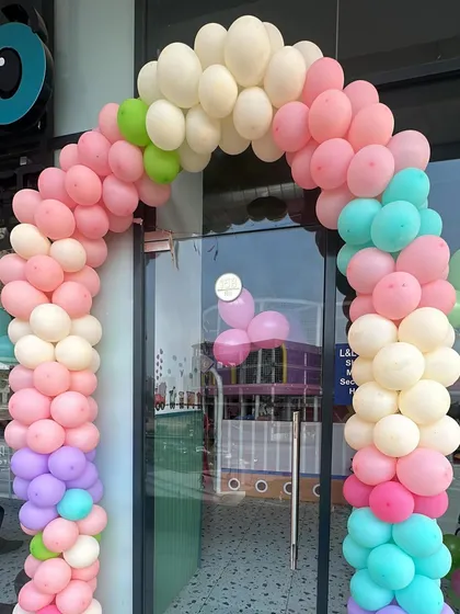A pastel balloon arch welcomes guests to a fun-filled day at Peek A Boo.