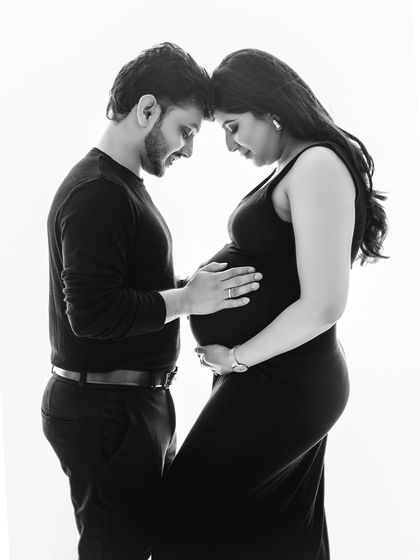 A strong and beautiful couple portrait in black and white. The high contrast and simple background create a striking image that focuses entirely on their connection.