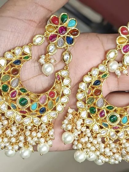 A stunning pair of navratan (nine-gem) chandbali earrings with pearl tassels. These multi-color earrings can be paired with many different outfits.