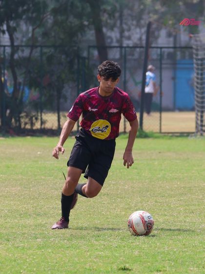 An action shot from the Thane Youth League, showing a player's focus and control while dribbling at speed.