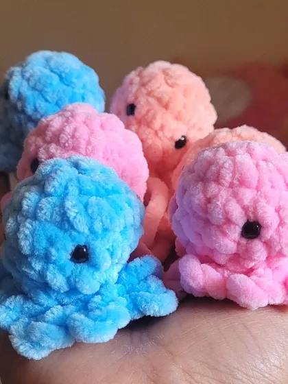 A handful of my fluffy octopus keychains, all ready to find new homes. I make these in a variety of pastel colors like pink, blue, and peach, using soft velvet yarn. They are the perfect cute accessory for your keys or to hang from a backpack.
