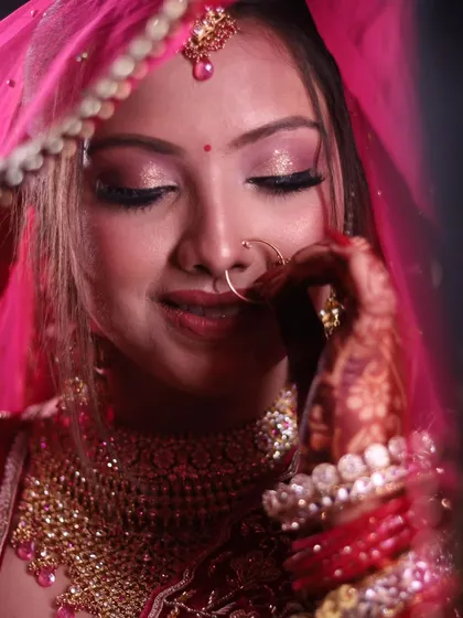A shy smile through the veil. This candid moment captures the sweet and coy side of the bride on her special day.
