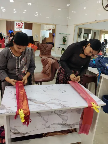 Hands-on practice is the core of my teaching. Here, students in my saree draping class are learning to create perfect pleats using my table-top method, ensuring each fold is precise.