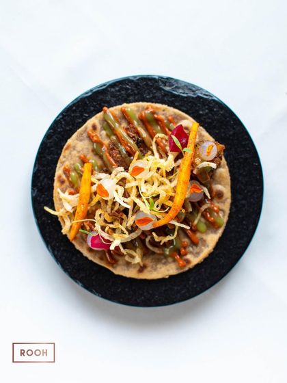The beautifully garnished Heeng Achar Kalhare Aloo taco, topped with crispy potato straws. A vegetarian delight from our "Rooh of Awadh" menu.