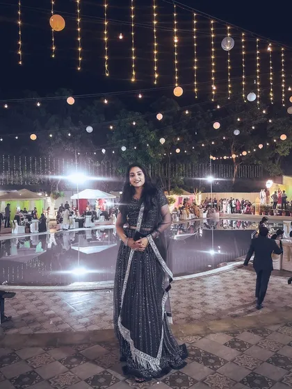 My partner enjoying the ambiance at an outdoor evening reception. The string lights and poolside setting were perfect.