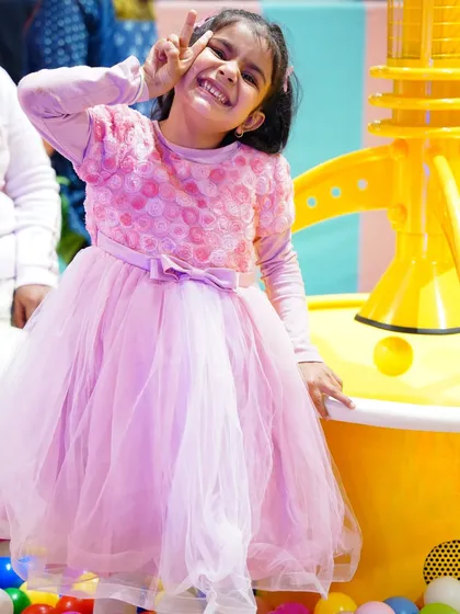 This birthday girl is striking a pose in her beautiful pink dress during her Rainbow High themed party.