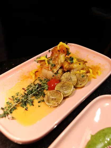 Grilled fish with lemon and thyme, presented with a vibrant yellow sauce. A simple yet elegant dish that speaks of freshness and quality.