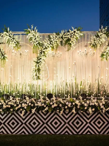 The same all-white stage, but with a modern twist. The addition of a black-and-white geometric pattern on the stage front adds a contemporary and graphic element.