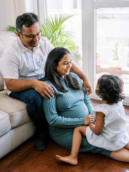 The whole family together, with their daughter looking up at her parents. Capturing these interactions before the new baby arrives is so important for creating a complete family story.