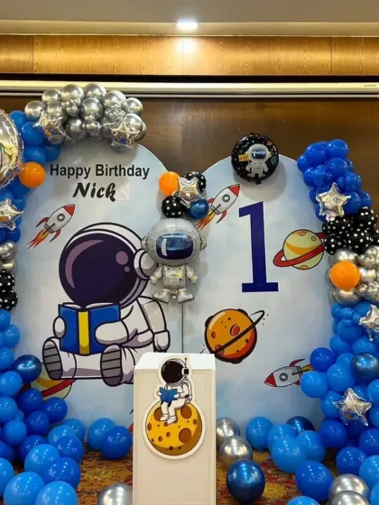 A closer view of the astronaut backdrop for Nick's party, showing the cute character and planet details.