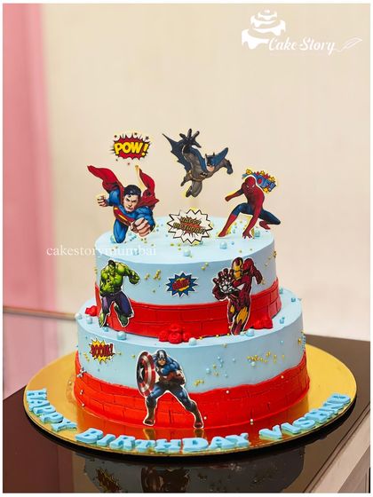 A two-tier cake for a true superhero fan. This design brings together the entire Avengers squad, including Superman, Batman, Spider-Man, Hulk, Iron Man, and Captain America.