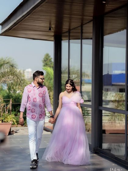 This expecting couple takes a stroll during their outdoor photoshoot. The lilac gown flows beautifully with every step, making it perfect for dynamic and candid shots.