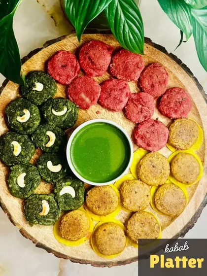 My vegetarian Kebab Platter is a celebration of color and flavor. It features a trio of my signature kebabs: beetroot, hara bhara, and galouti, all served on a rustic wooden board with a vibrant green chutney for dipping.