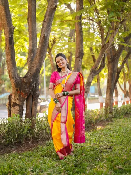 A full-length portrait of the bride, leaning against a tree. The pose is relaxed and graceful.