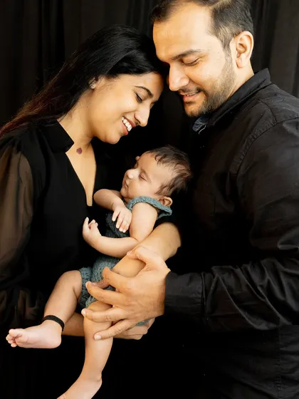 The three of you, in your own perfect bubble. I guide you into comfortable, natural poses that highlight your new family bond against a simple, clean black backdrop.