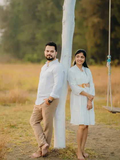 A relaxed portrait of Milan and Pranali by a tree. This casual pose is great for capturing the couple's natural interaction in an outdoor environment.