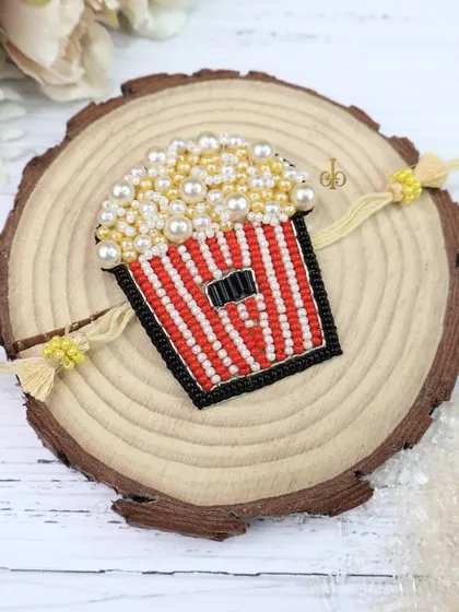 This beaded weave Rakhi is designed like a box of popcorn, making it a quirky and fun gift for a movie-loving sibling.