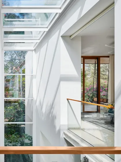 Looking across the connecting bridge in the Split House, you can see how the large skylight floods the multi-level space with natural light. This design element is key to the home's open and airy feel.