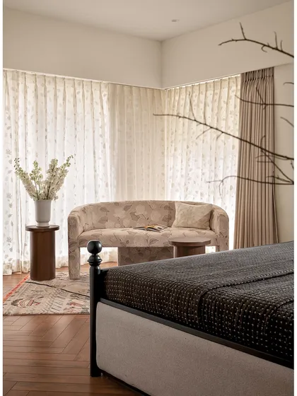 This shot from the master bedroom shows the cozy seating nook by the window. The plush sofa and soft curtains create a perfect spot for reading or simply enjoying the view.