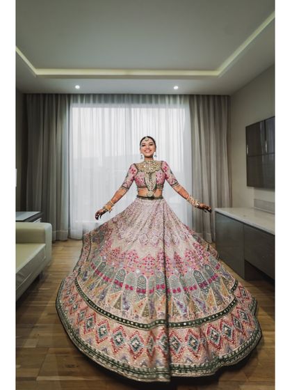 A full-length twirl shot of the bride, showing the beautiful flare of her heavy lehenga. A must-have shot for every bride.