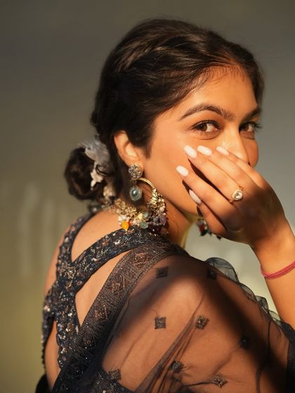 A close-up on the back details and accessories for this lehenga look. The criss-cross back design adds a modern touch, while the traditional earrings complete the festive ensemble.