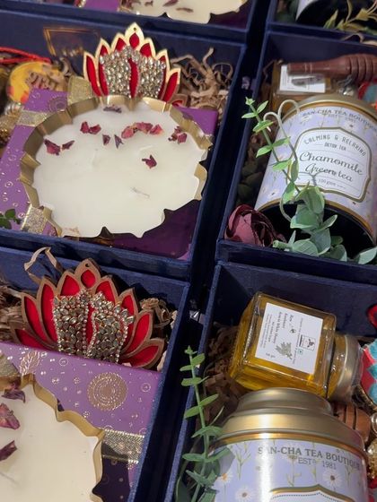 A detailed shot of the purple-themed Diwali hamper, showing the lotus-crowned candle and the jar of premium honey.