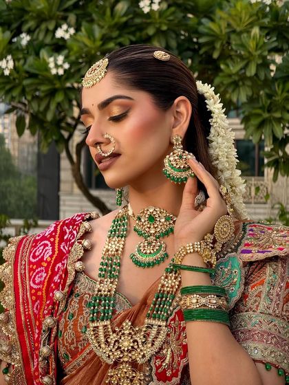 A side profile showcasing the beautiful gajra (floral hair accessory) and the intricate details of the makeup and jewellery.