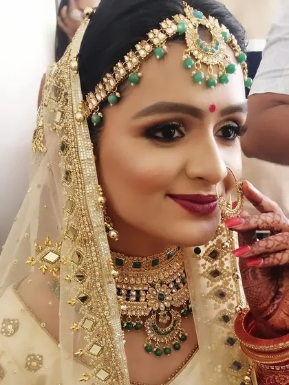 A happy bride is the most beautiful bride. This stunning look for a North Indian wedding features dramatic smokey eyes, a deep red lip, and glowing skin, all coming together to create a truly memorable bridal moment.