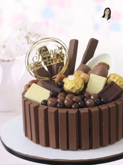 For the ultimate chocolate lover, this decadent chocolate overload cake is a dream come true. It's surrounded by KitKat bars and generously topped with a variety of chocolates, including Ferrero Rocher, making it a truly indulgent birthday treat.