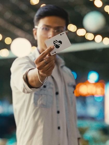 The Ace of Spades, the most iconic card in the deck. Holding it up against a beautiful bokeh background.