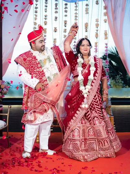 The couple celebrates their union under a shower of rose petals, a classic and joyous wedding moment.