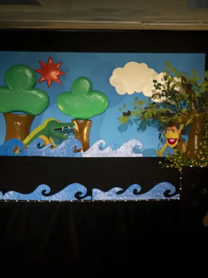 The clever monkey hides in a tree from the crocodile in this scene from the classic Panchatantra tale. The use of rod puppets allows for dynamic movement across the stage.