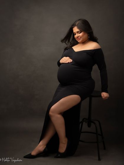 A powerful and chic seated pose in a black gown. This look is modern, confident, and utterly stunning.
