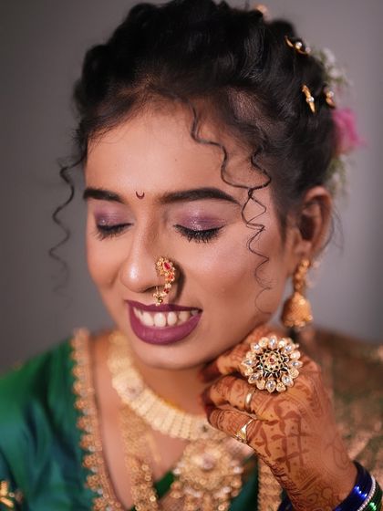 A close up of a bride with curly hair, showing her beautiful smile and the soft purple eyeshadow I used.