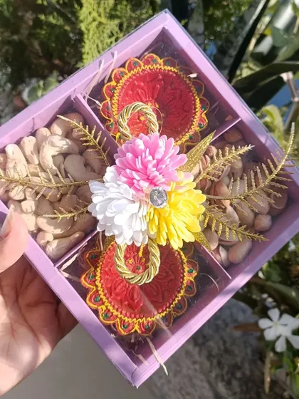 A mini gifting box perfect for Diwali, containing cashews, pistachios, and two beautiful handmade diyas.