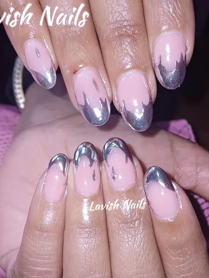 A creative "drip" effect French manicure using silver chrome on oval-shaped nails.