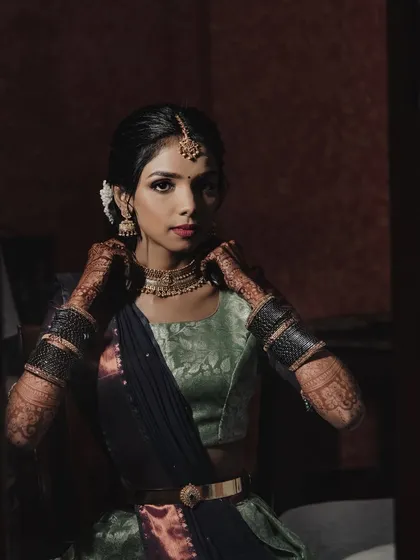 A moody, artistic shot of the bride. The makeup looks striking even in low light, showcasing its versatility.