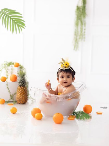 A wider shot of the fruit bath setup, showing the pineapple and other decorative elements that complete the tropical theme.