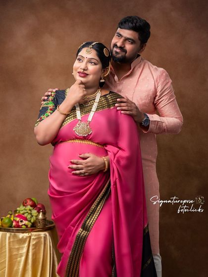 An elegant maternity portrait of a couple in traditional attire, capturing their excitement and love as they await their new arrival.
