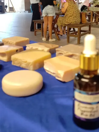 A close-up of my stall display, with the Rosemary & Peppermint Hair Oil bottle in focus and soap bars in the background.