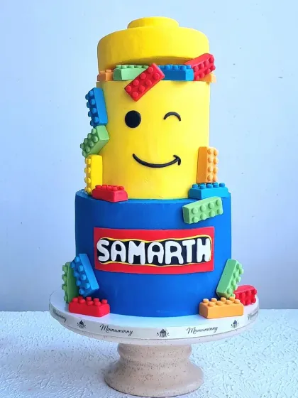 A full shot of the Lego cake on its stand, showing the complete two-tiered design.