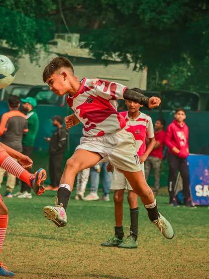 A player executes a flying header, a demonstration of bravery and skill.