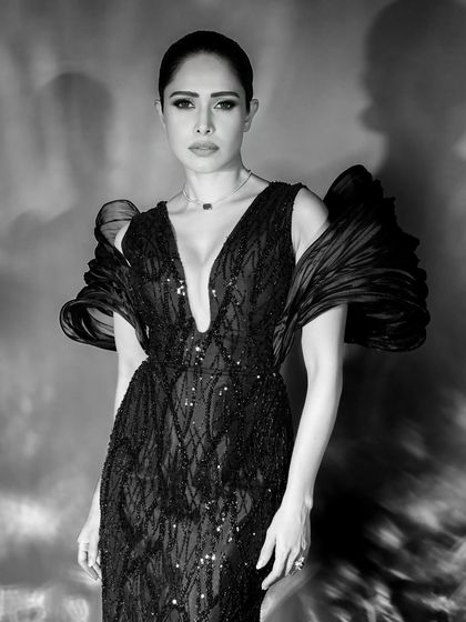 A three-quarter portrait that captures a strong and confident stance, with the dramatic sleeve details of the gown adding a high-fashion touch.