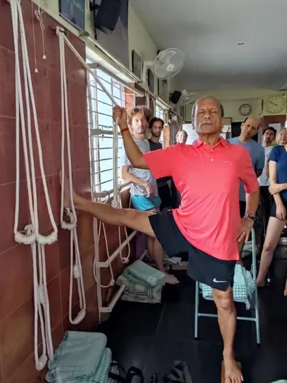 A standing leg stretch using wall ropes.