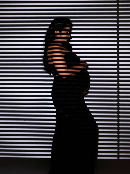 An artistic silhouette created with striped lighting from window blinds.